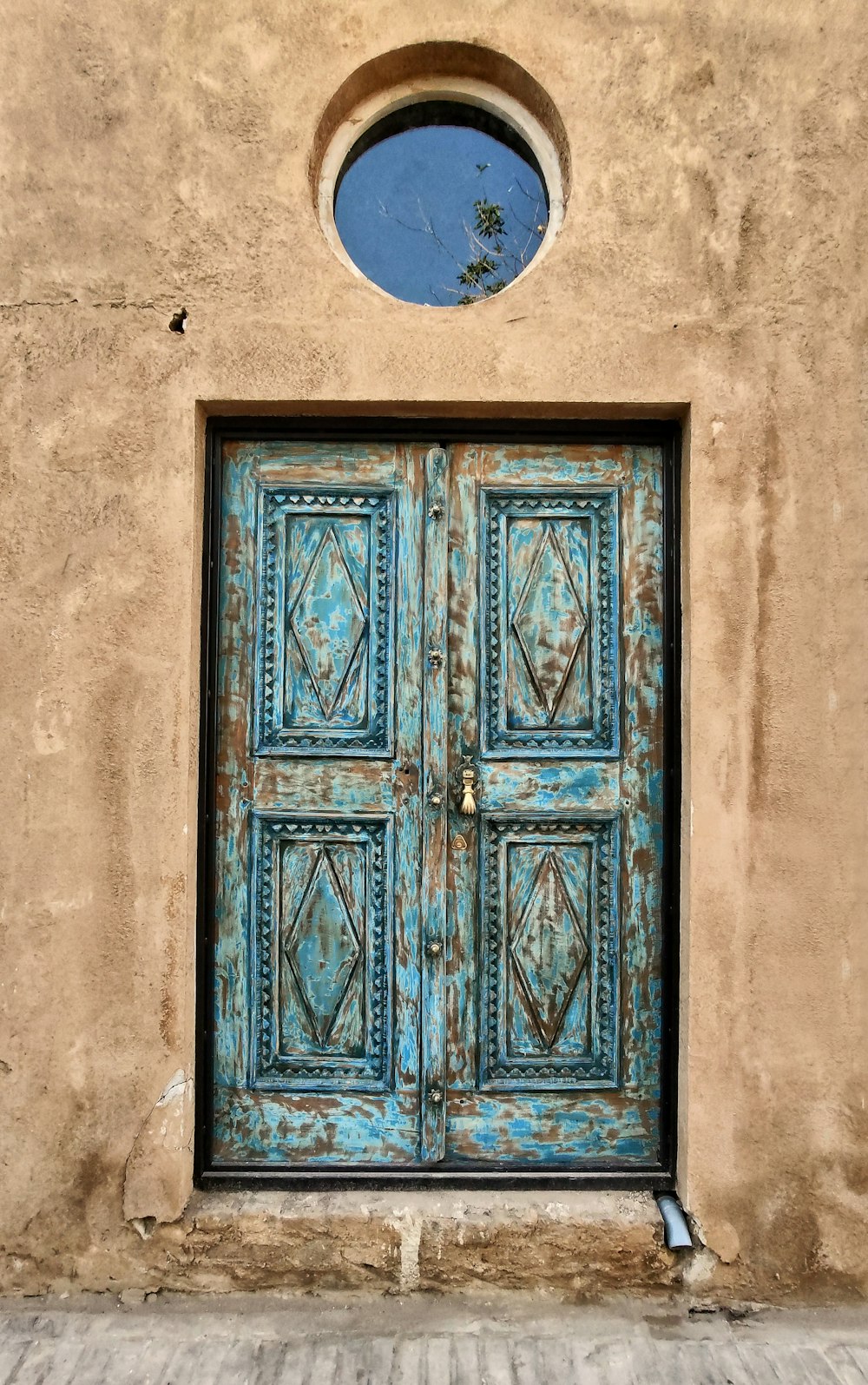 puerta de madera azul sobre pared de hormigón blanco