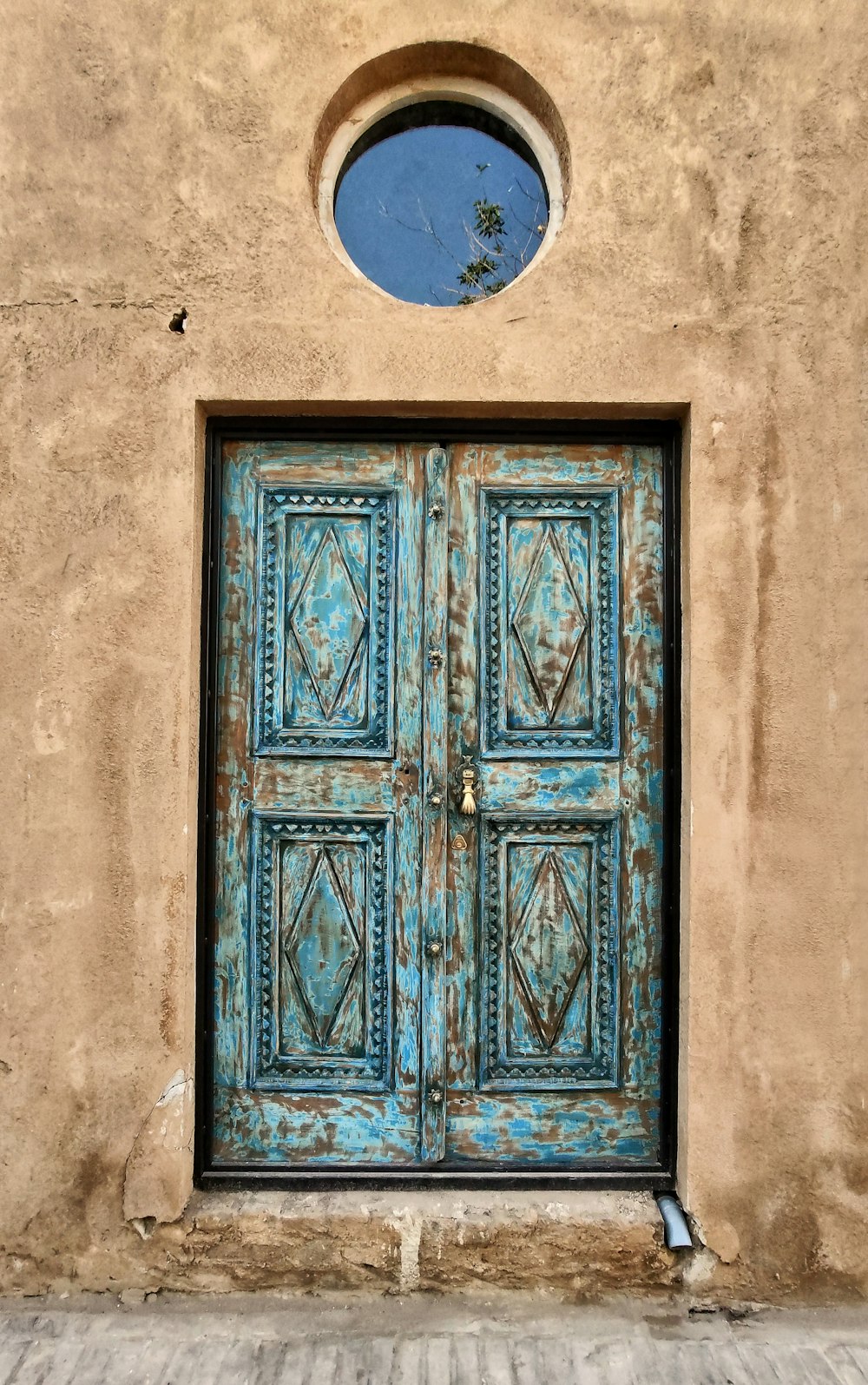 blue wooden door on white concrete wall