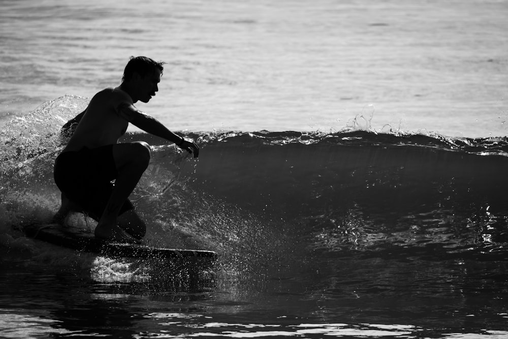 grayscale photo of girl in wet suit on water