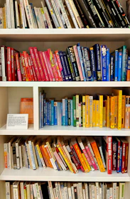 yellow blue red and green books on white wooden shelf