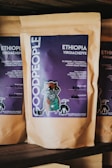 A package of coffee labeled 'GOOD PEOPLE' with details about Ethiopian Yirgacheffe coffee featuring blueberry, strawberry, honey, and chocolate notes. The packaging includes artistic illustrations and handwritten notes regarding the roast date and roaster’s name.