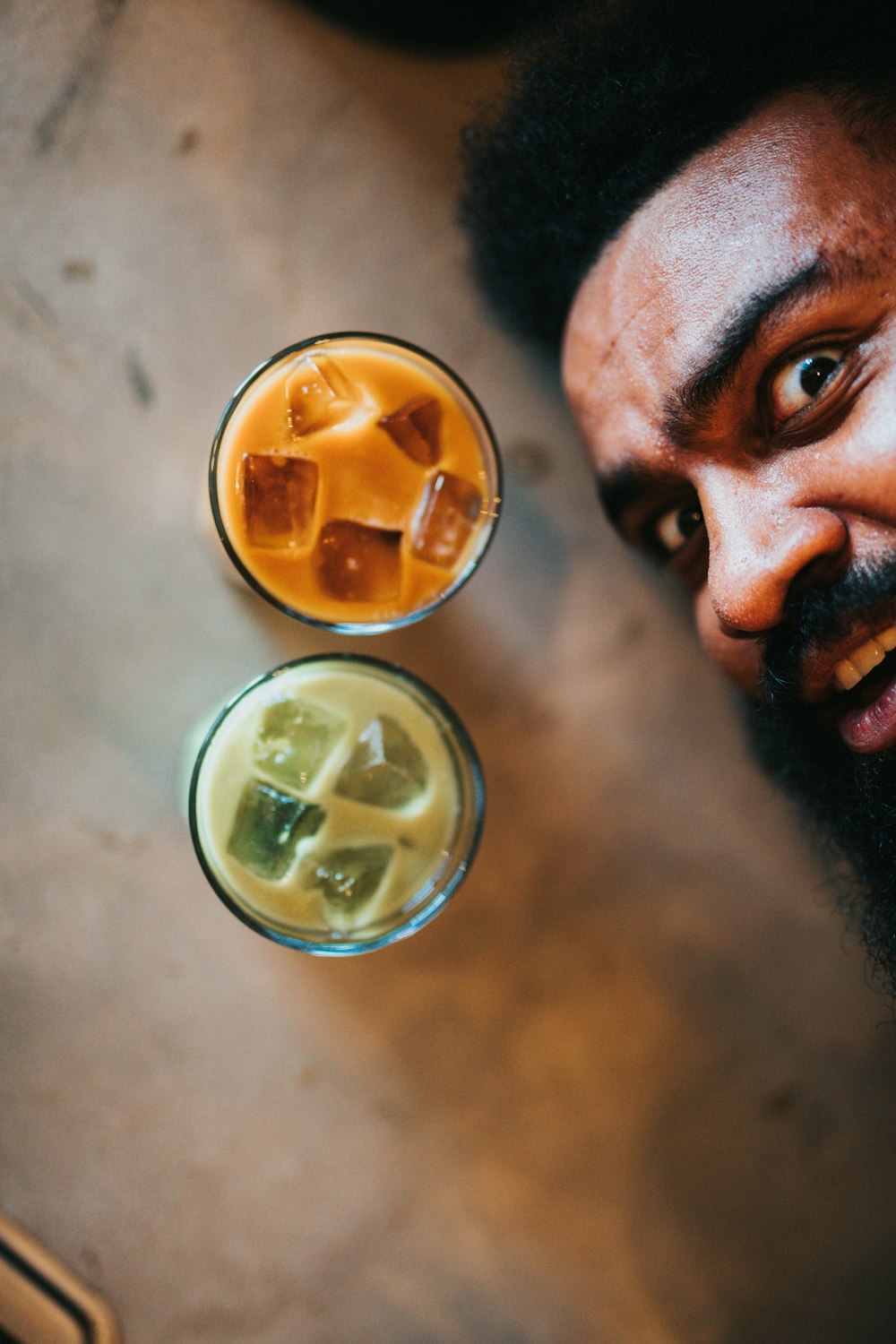 man with yellow liquid in drinking glass