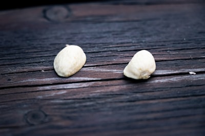 Handful of black seeds resting on a wooden surface with natural light.