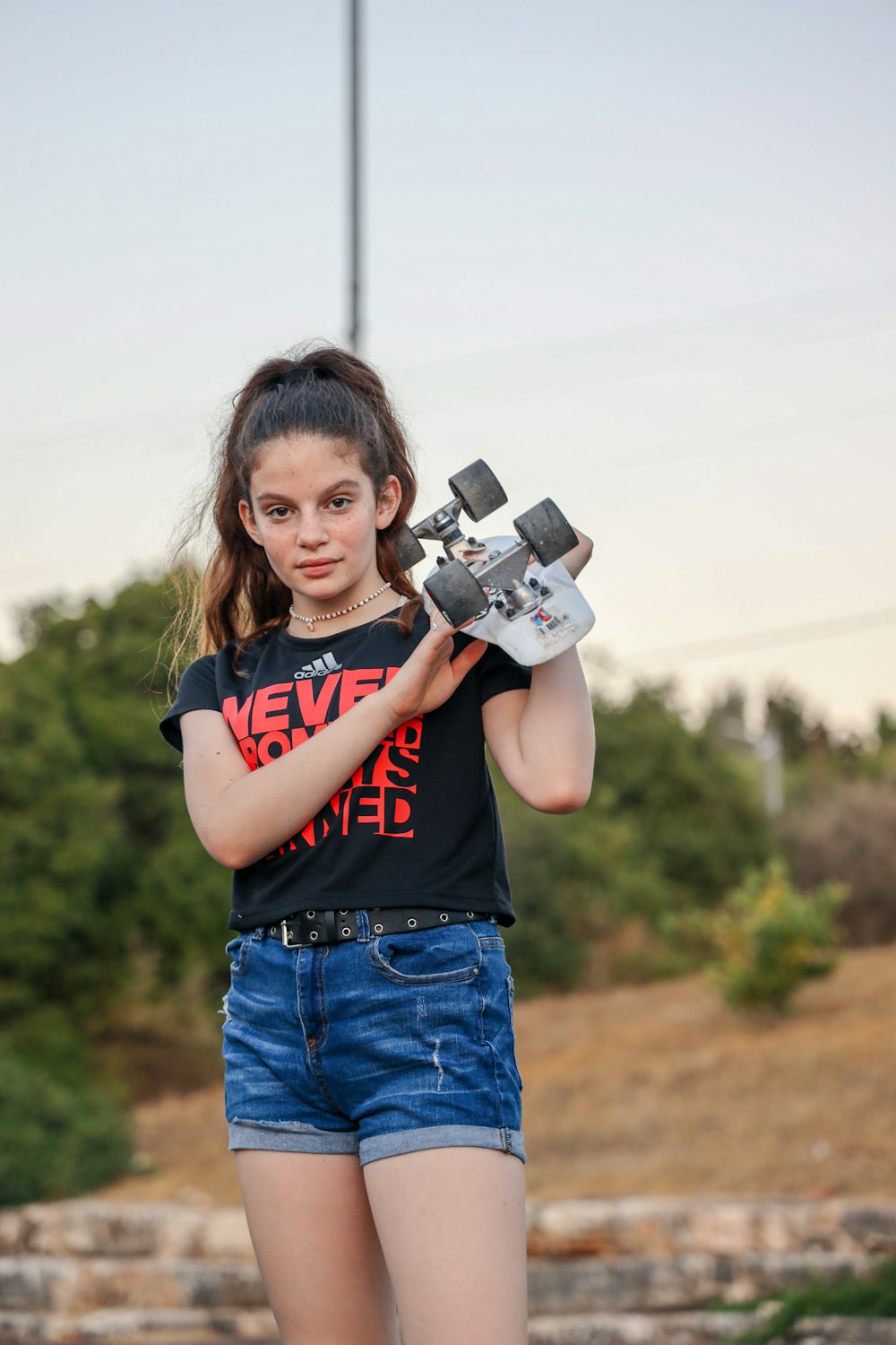 girl in red and black crew neck t-shirt holding gray and black camera