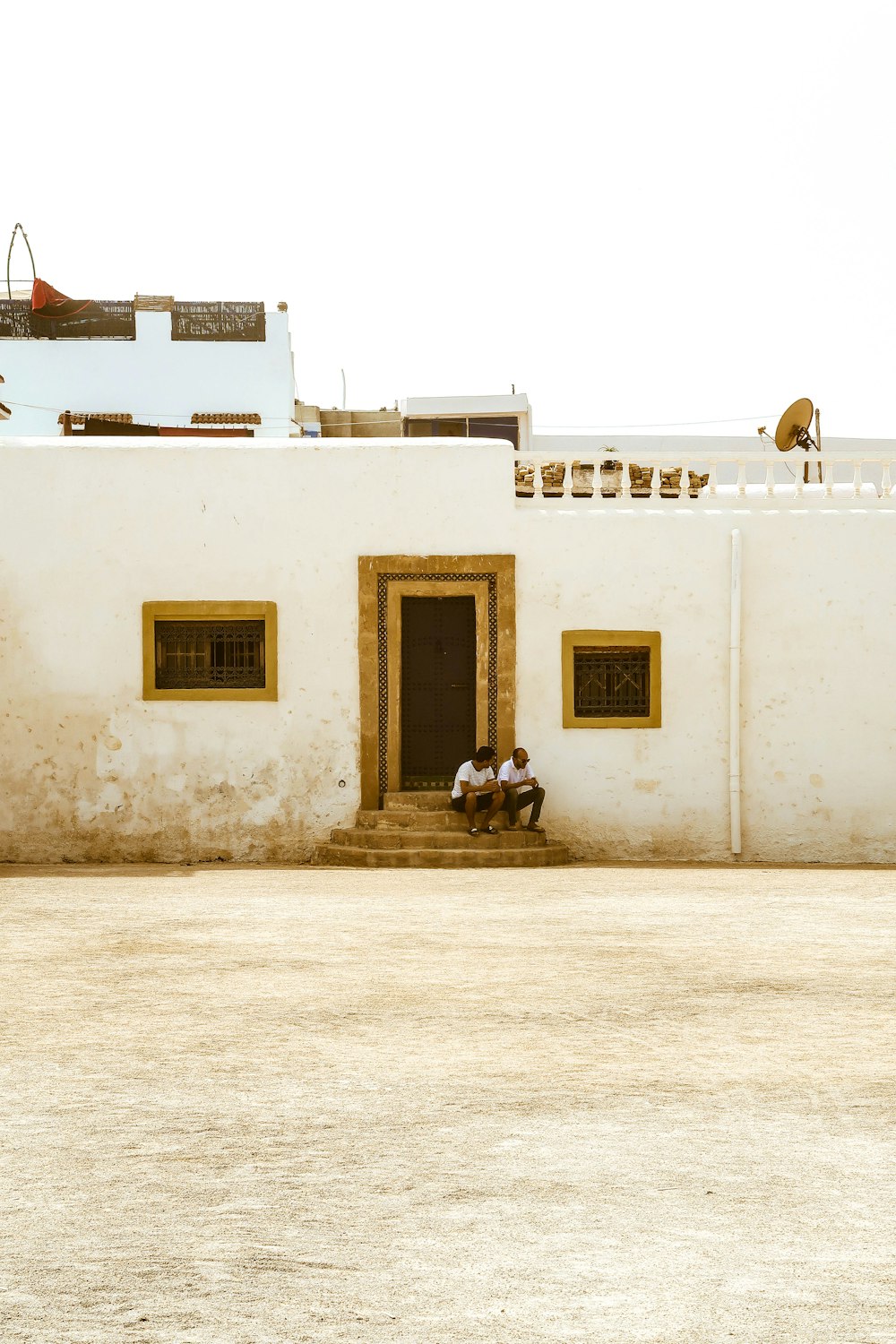 white concrete building with white and black motorcycle parked beside white concrete building during daytime