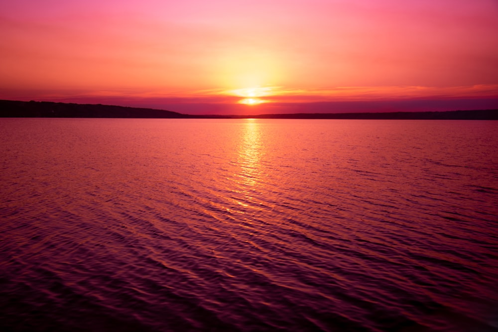 Ruhiges Meer unter orangefarbenem Himmel bei Sonnenuntergang