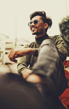 A smiling model posing with casual wear in a bright urban setting.