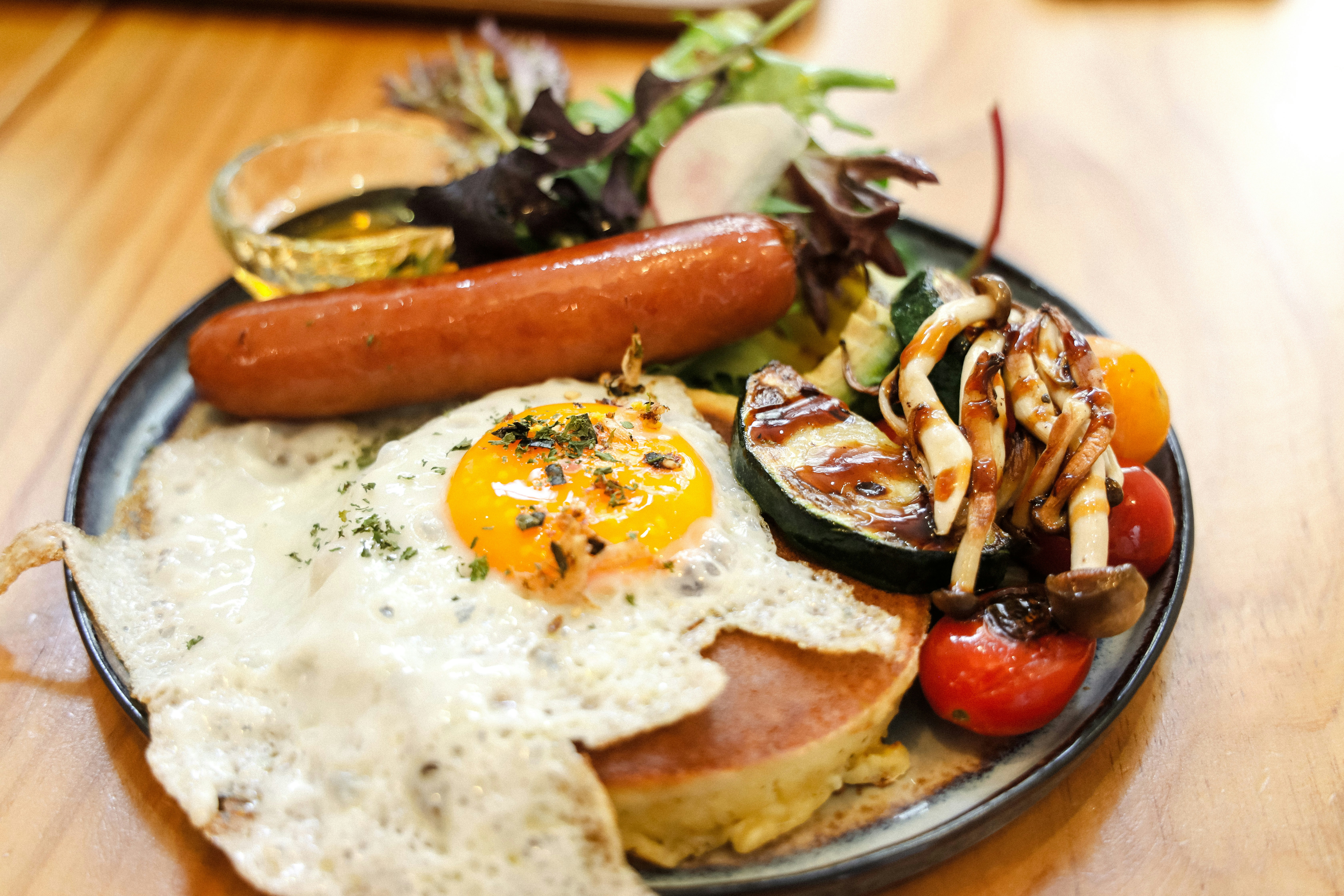 スライスしたトマトと緑の野菜を白い陶板に