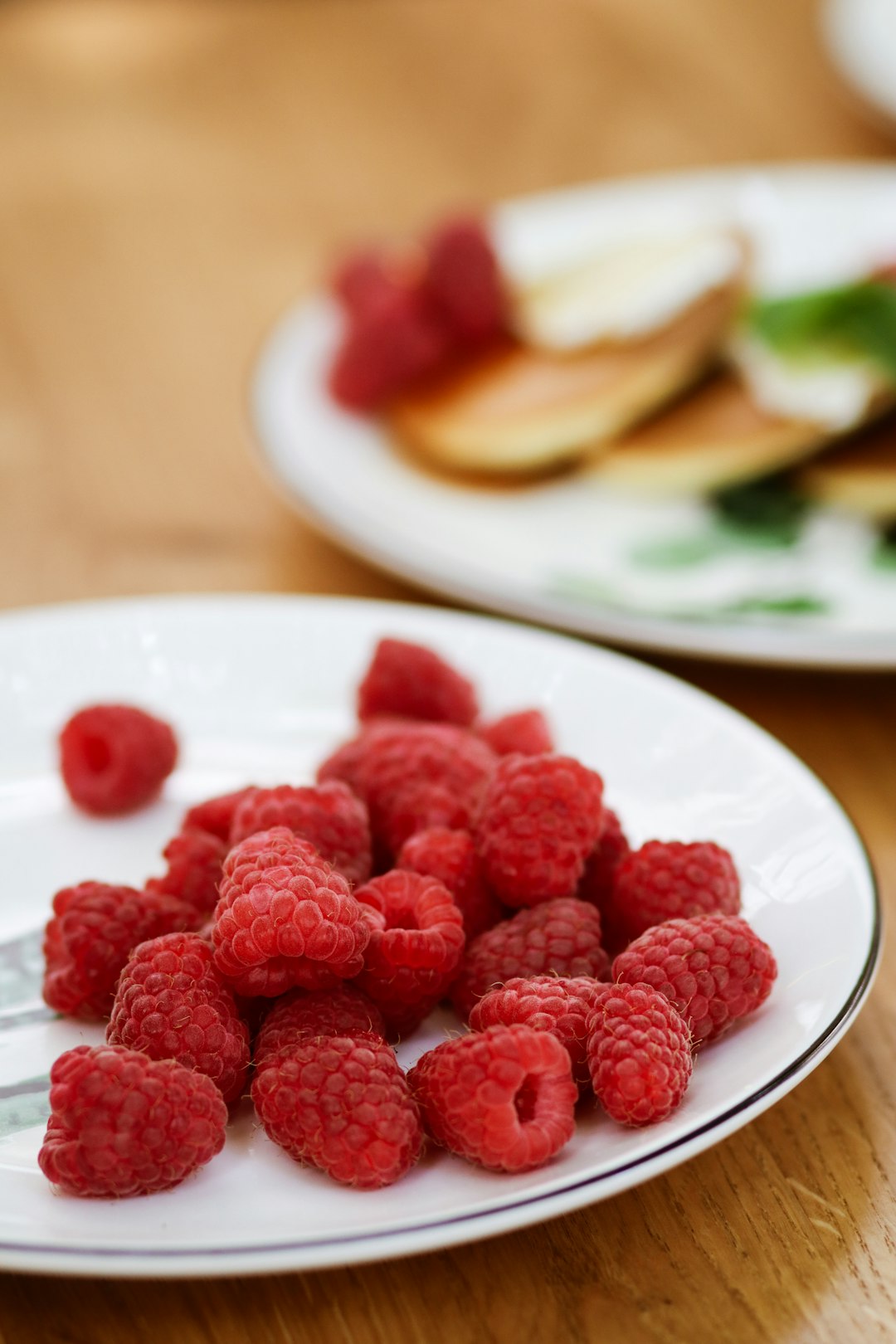 red raspberry on white ceramic plate