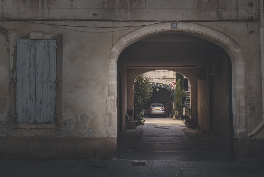 Auto nera parcheggiata accanto all'edificio in cemento grigio durante il giorno