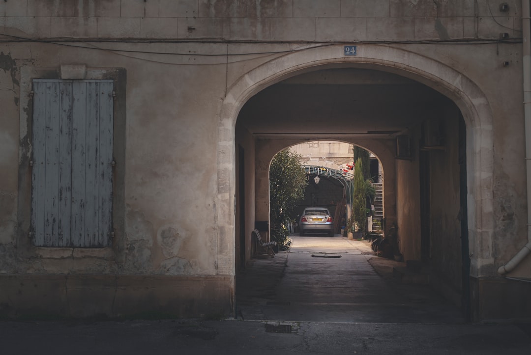 black car parked beside gray concrete building during daytime