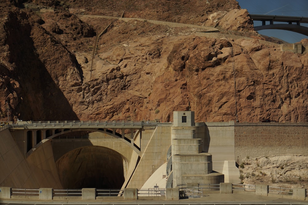 white concrete bridge on brown rocky mountain during daytime