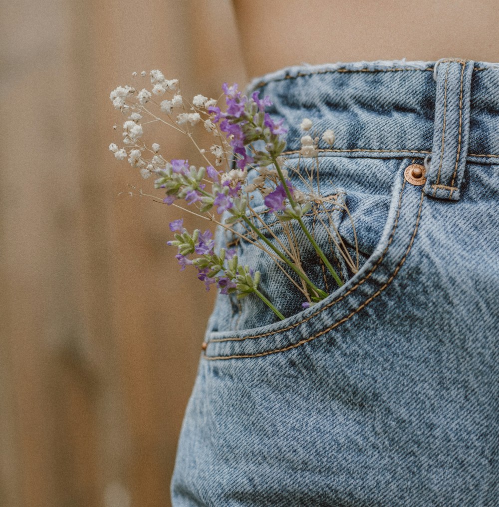 flor roxa em shorts jeans azuis