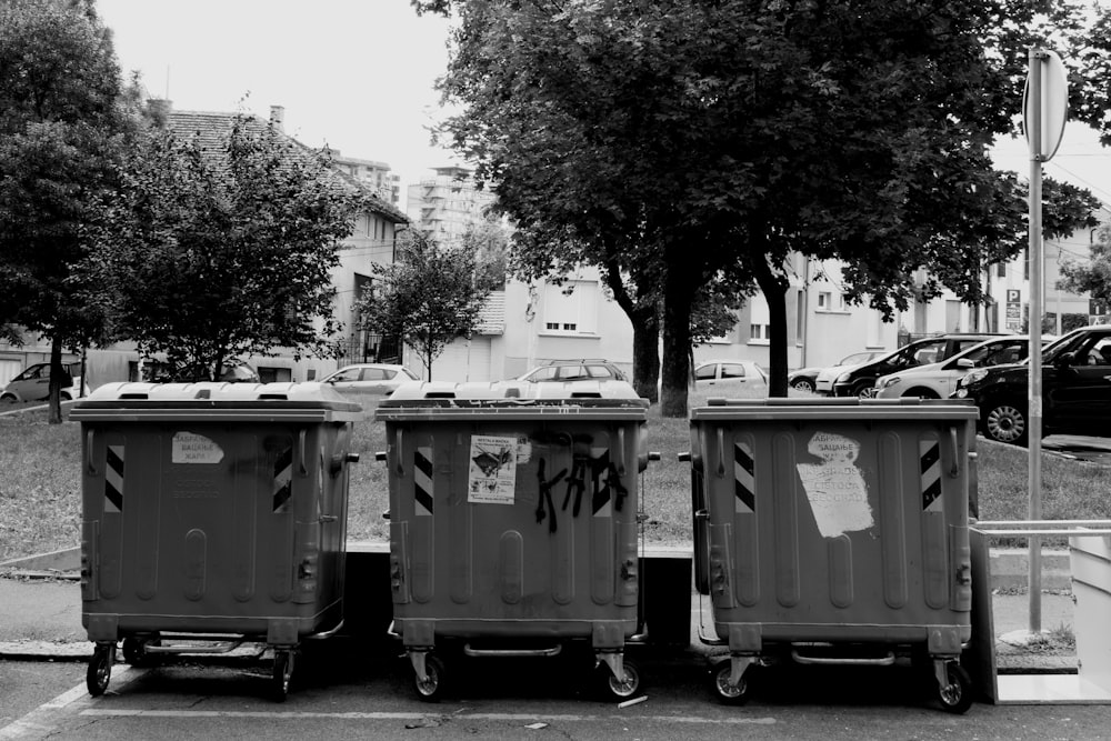 grayscale photo of trash bins
