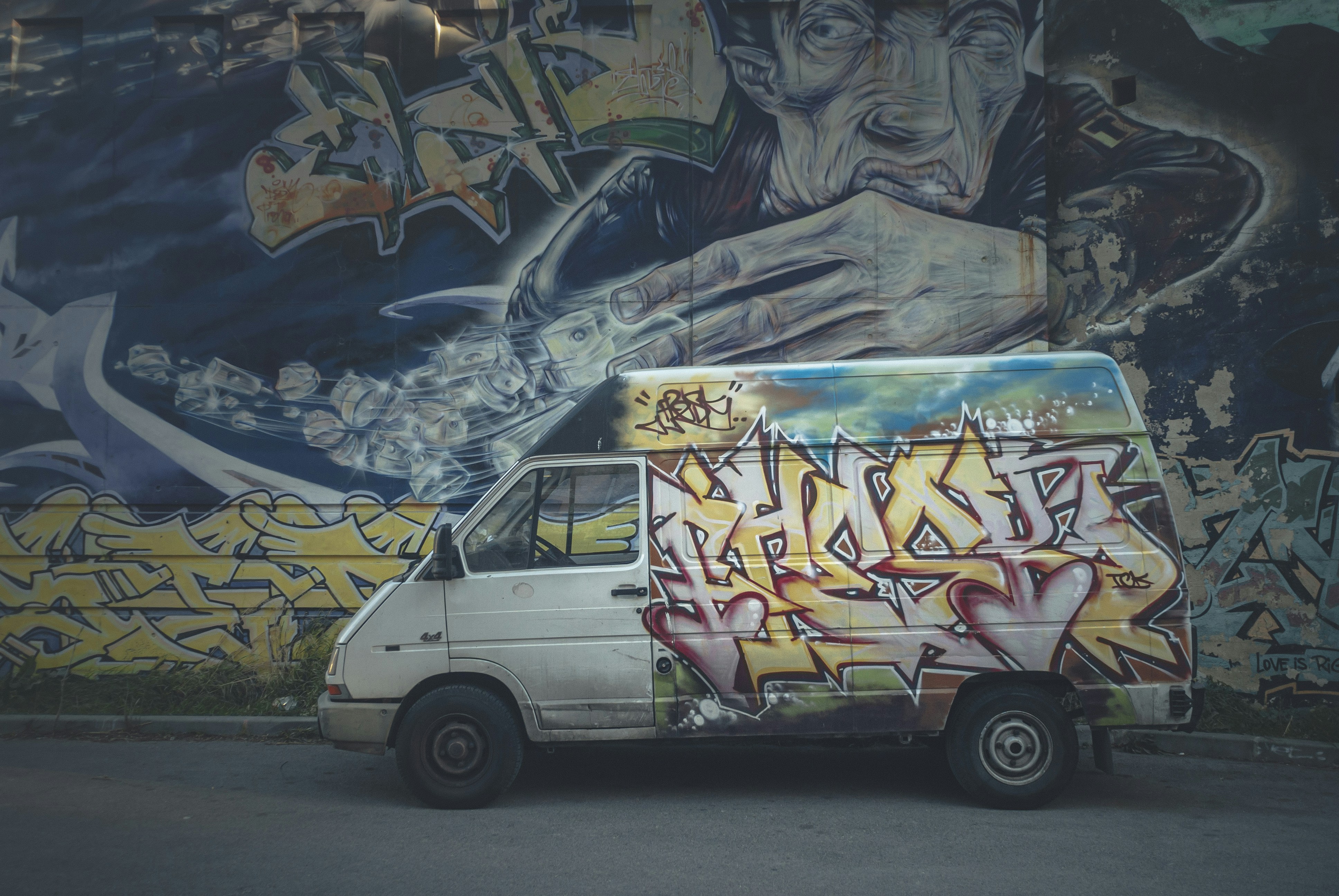 white yellow and blue van, An old minibus, painted with graffiti.