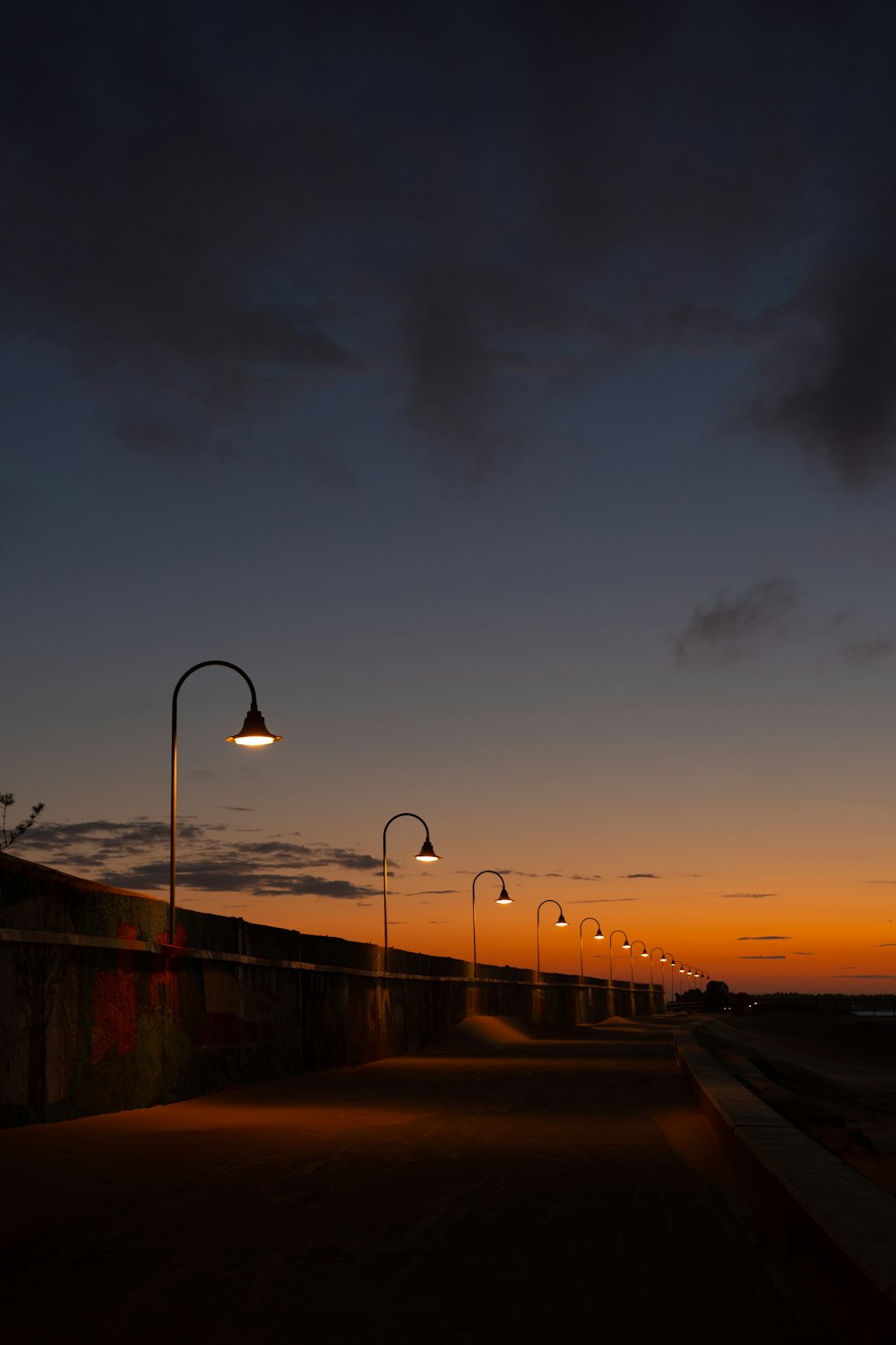 street light near body of water during sunset