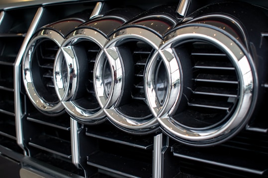 A close-up view of the front grille of a car featuring shiny metallic rings in a horizontal alignment.