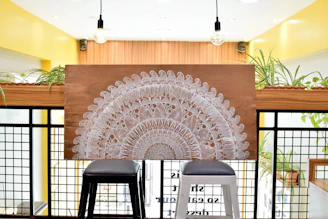 Close-up of a decorative wooden panel with carved spiritual motifs in a serene home setting.