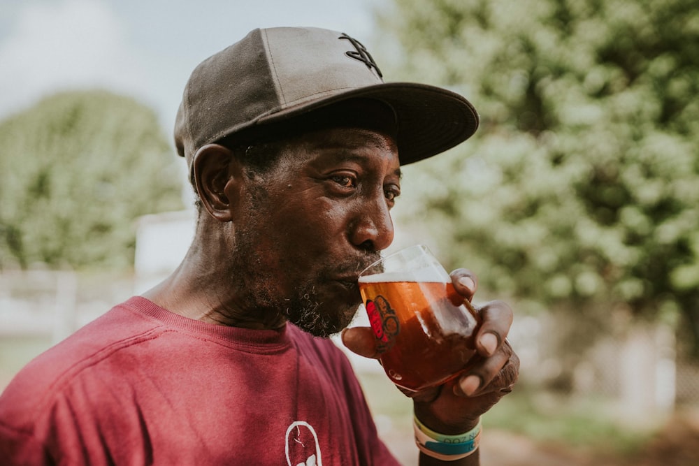 man in red crew neck shirt drinking beer