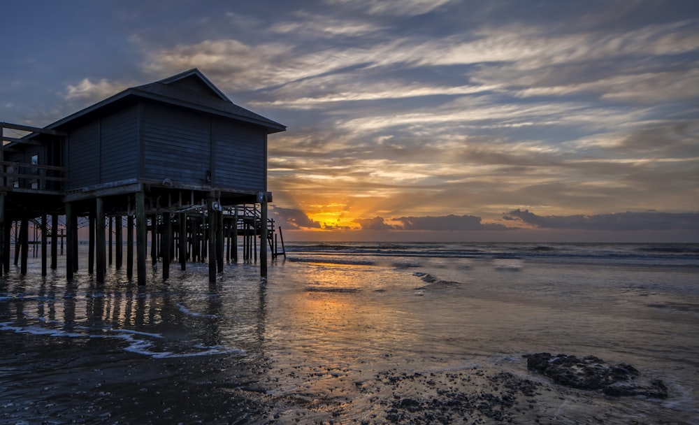 brown wooden dock on sea during sunset