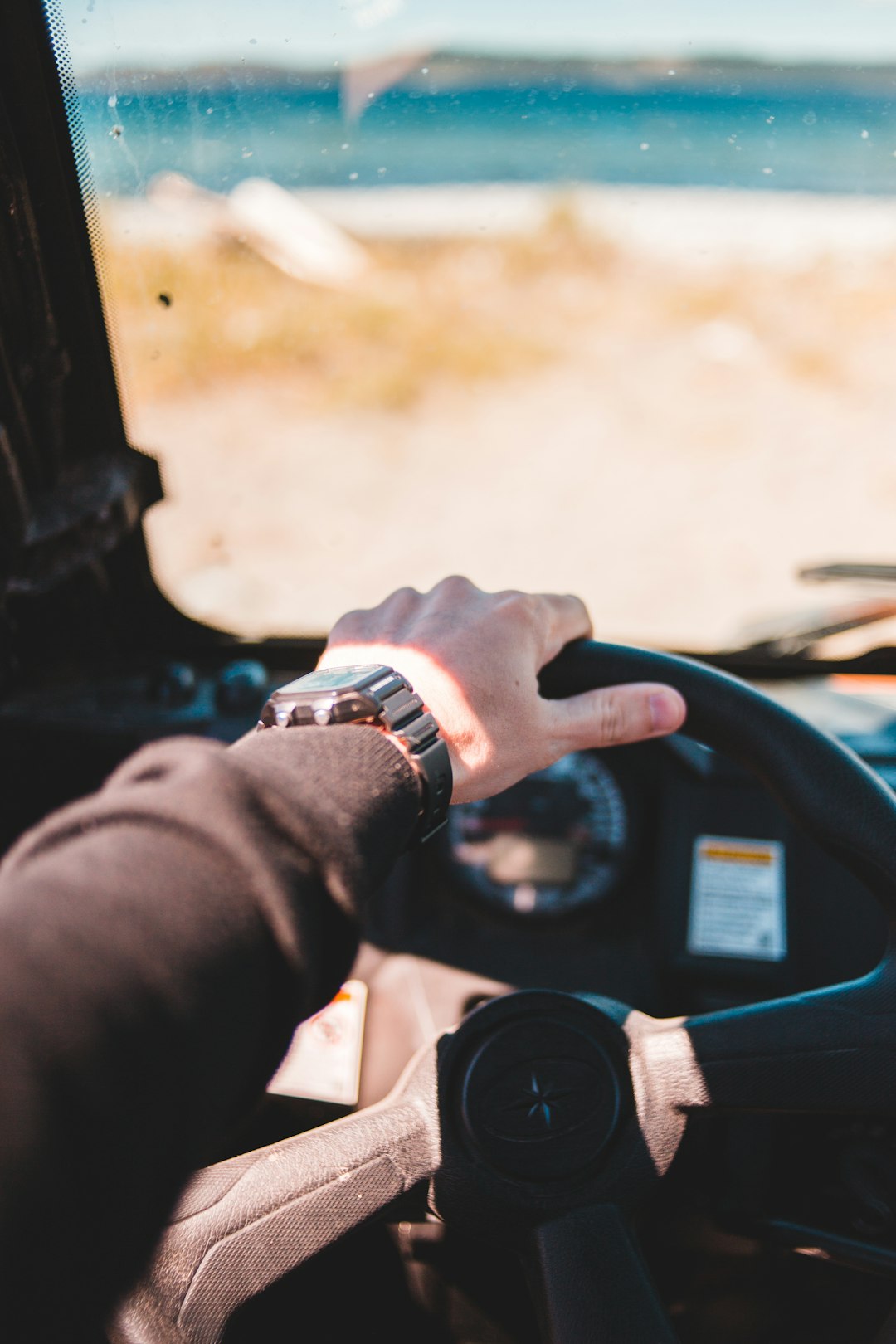 person in black long sleeve shirt holding black steering wheel