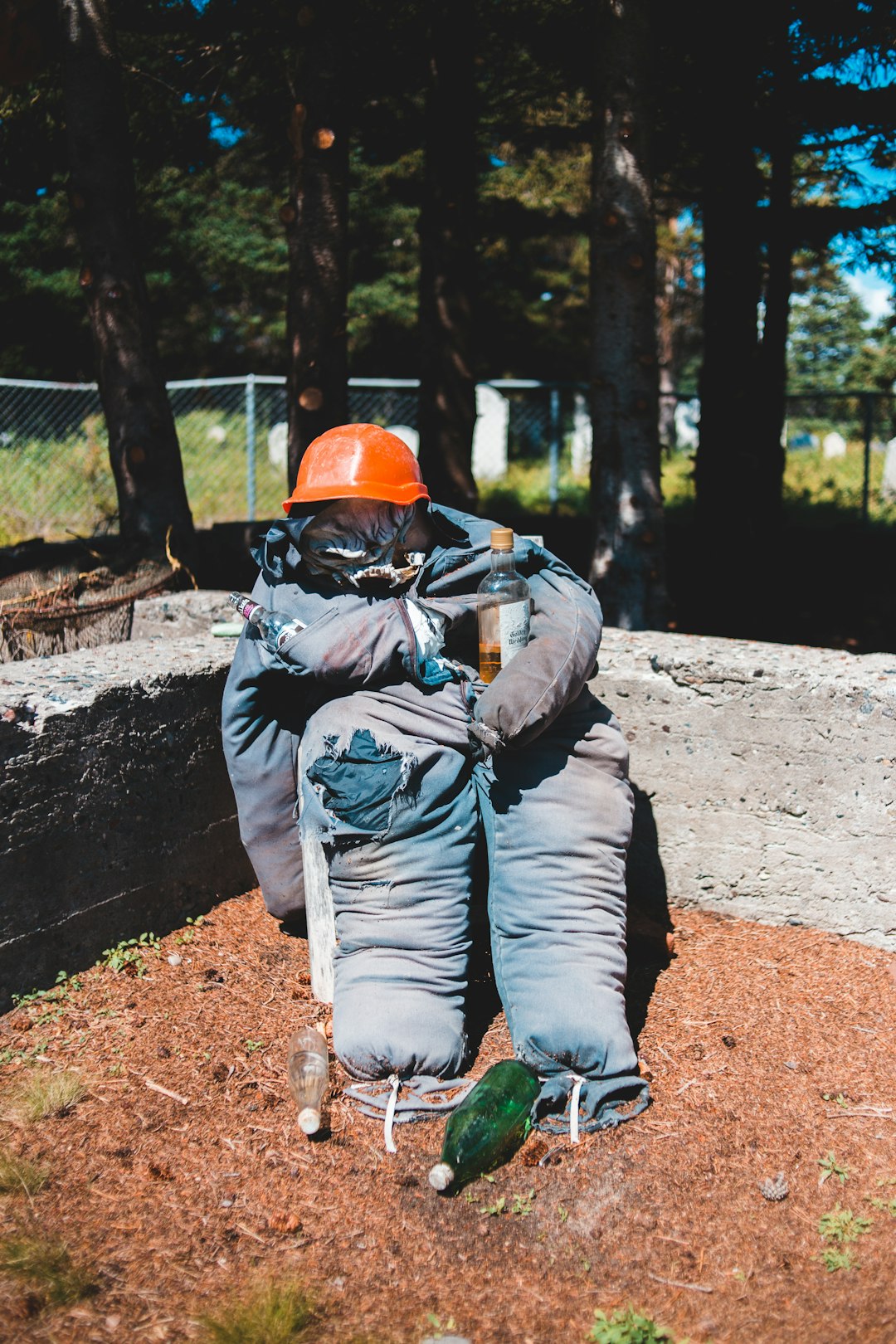 man in gray jacket and blue denim jeans sitting on brown rock during daytime