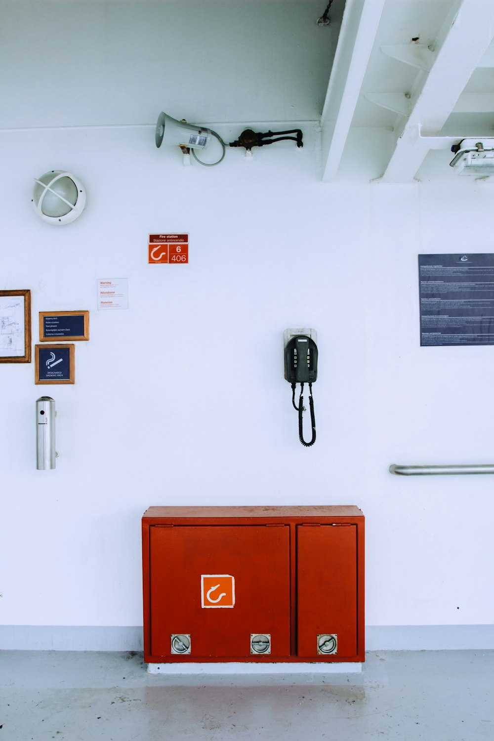 red and black cabinet beside white wall