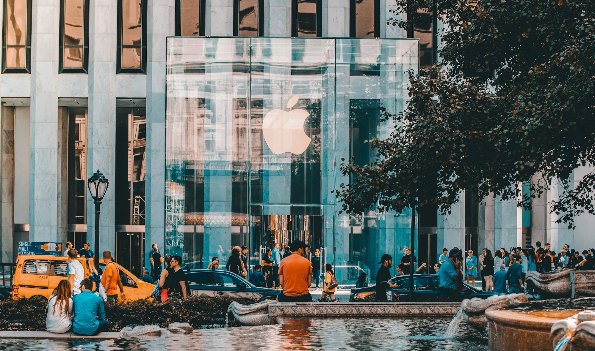 A man sitting outside of the majestic architecture masterpiece that is the Apple Store at Fifth Avenue in New York City. Just days after the iPhone 11 was released.