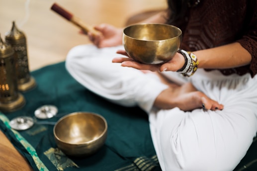 A person holding a singing bowl during a sound therapy session, creating healing vibrations