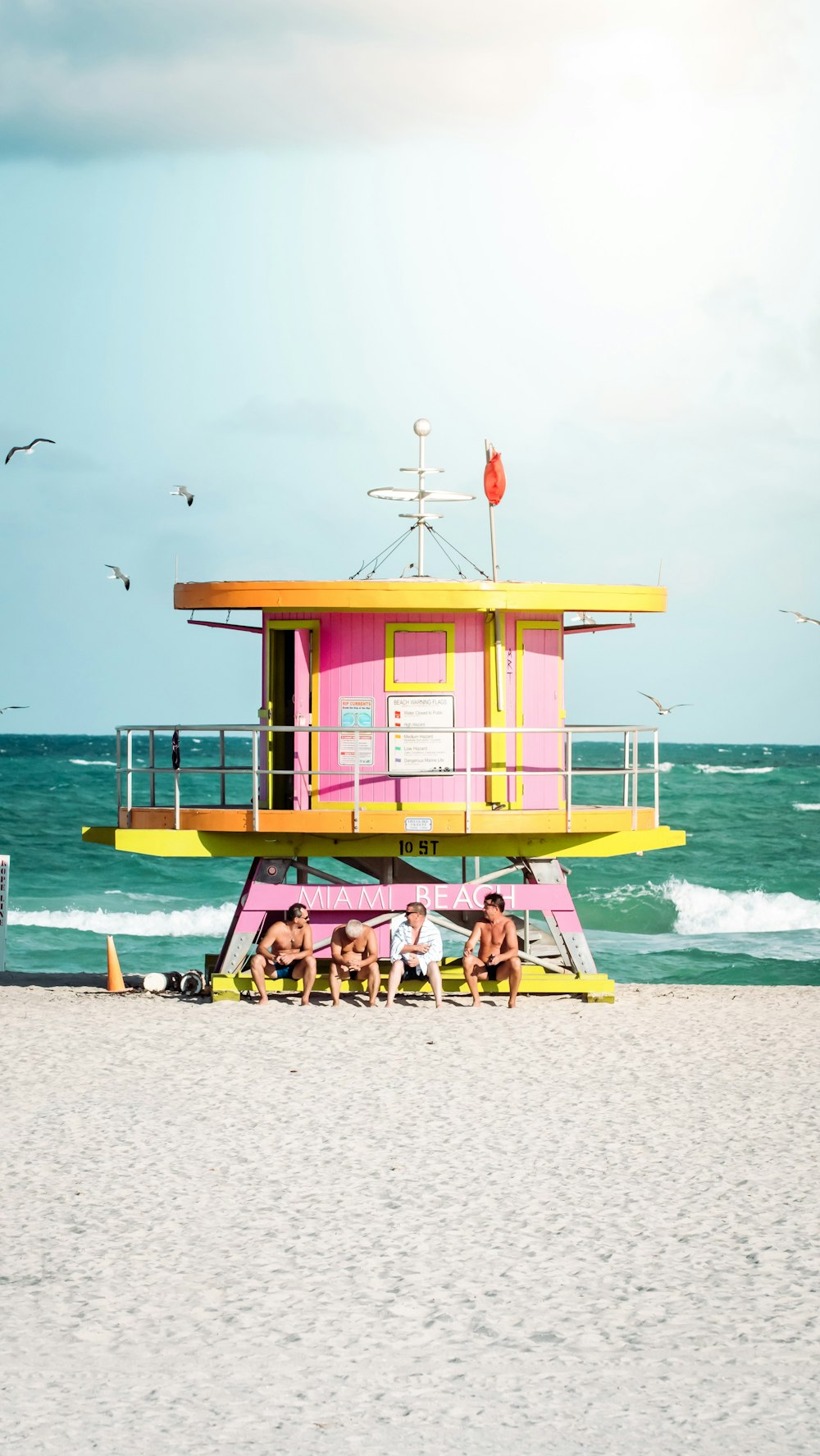 Casa de salvavidas de madera rosa y amarilla en la playa durante el día