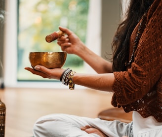 woman in brown knit sweater holding brown ceramic cup