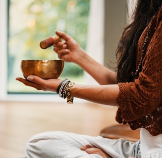 woman in brown knit sweater holding brown ceramic cup