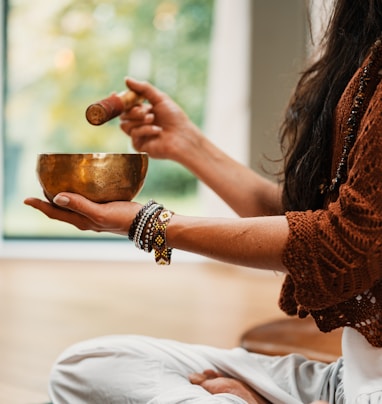 woman in brown knit sweater holding brown ceramic cup