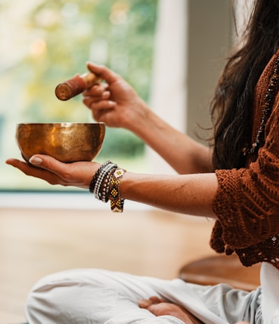 woman in brown knit sweater holding brown ceramic cup