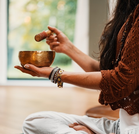 woman in brown knit sweater holding brown ceramic cup