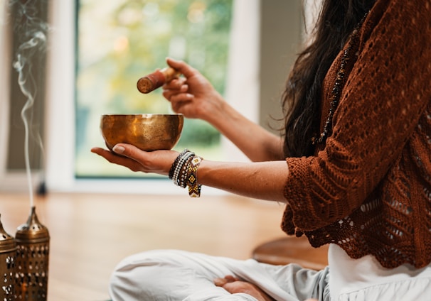 woman in brown knit sweater holding brown ceramic cup