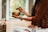woman in brown knit sweater holding brown ceramic cup