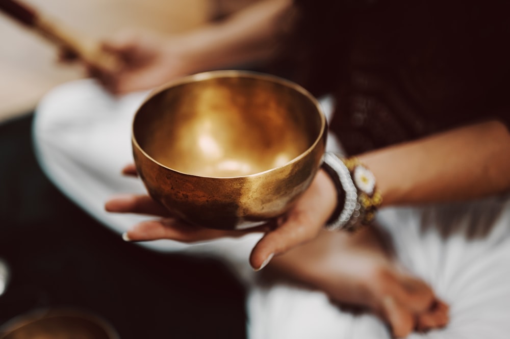 person holding brown ceramic bowl