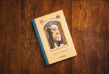 white and blue book on brown wooden table