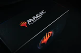 A sleek booster box with vibrant artwork and a secure magnetic closure.
