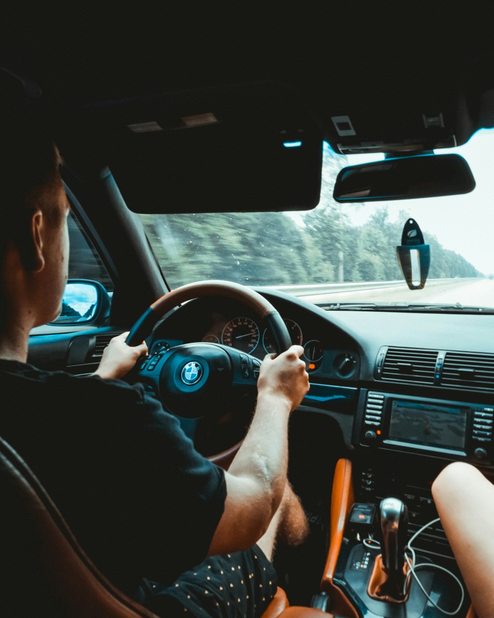 Hombre en camiseta sin mangas negro conduciendo coche