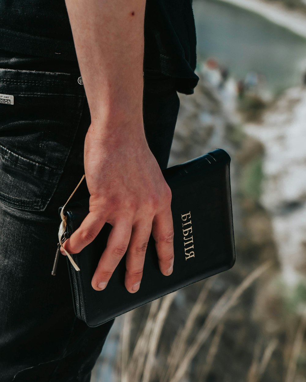 person in blue denim jeans holding black samsung android smartphone