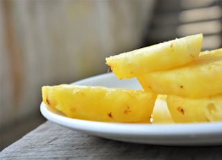 sliced yellow fruit on white ceramic plate