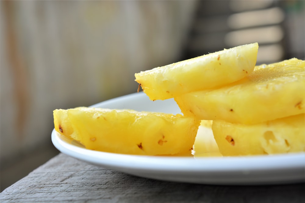 sliced yellow fruit on white ceramic plate