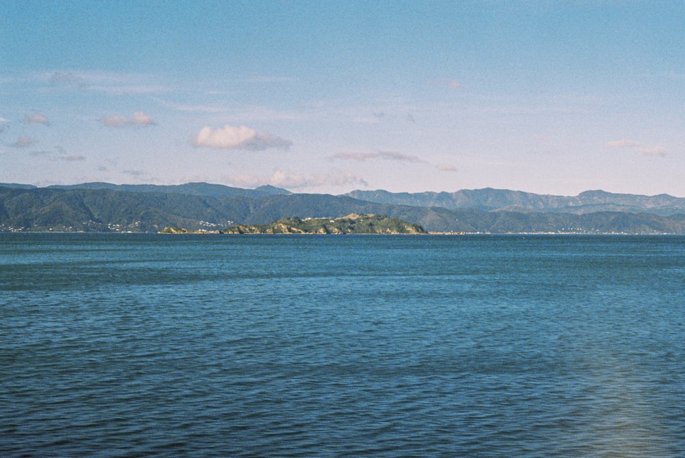 blue sea near mountain under blue sky during daytime