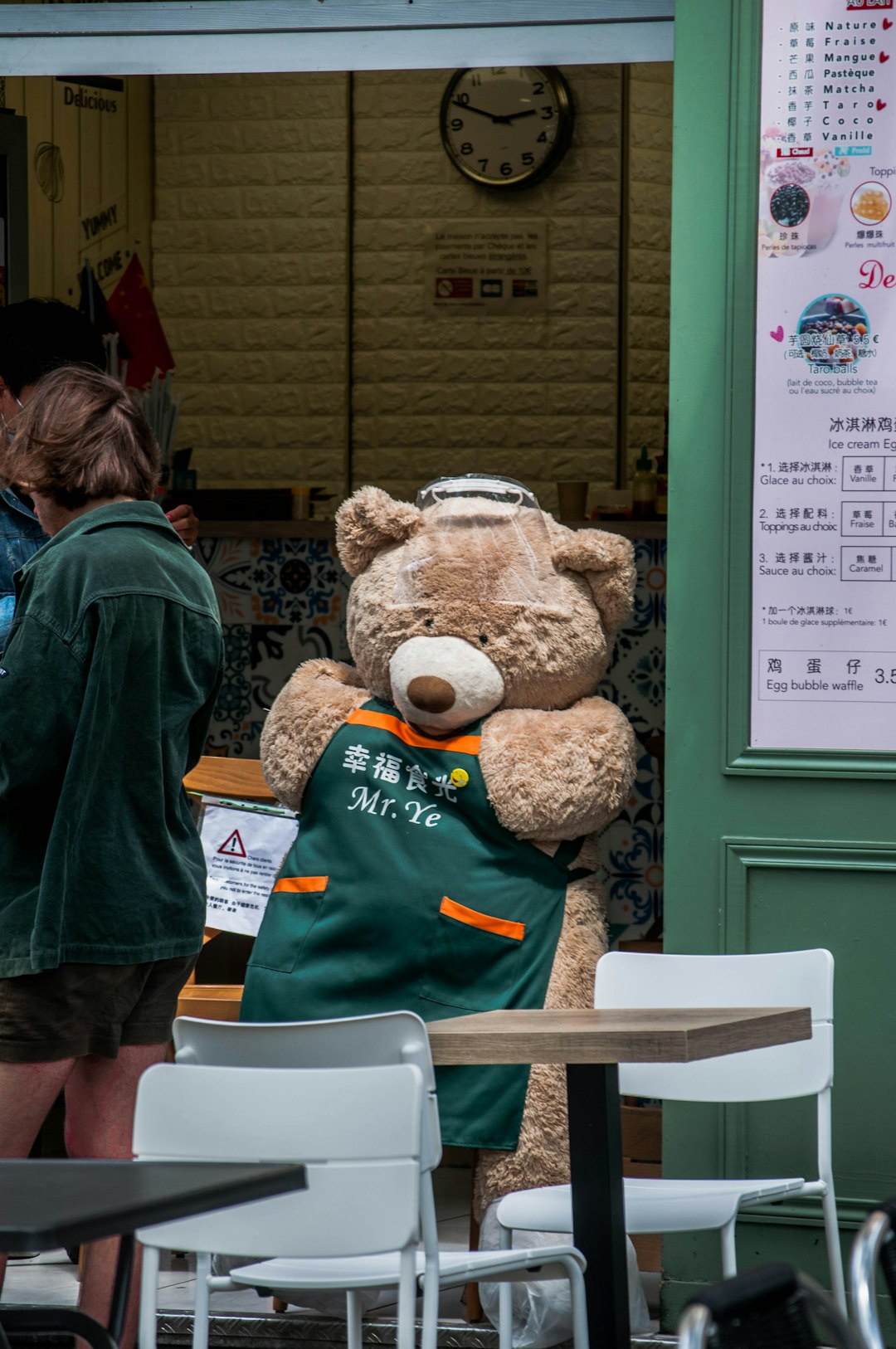 brown bear plush toy wearing green jacket