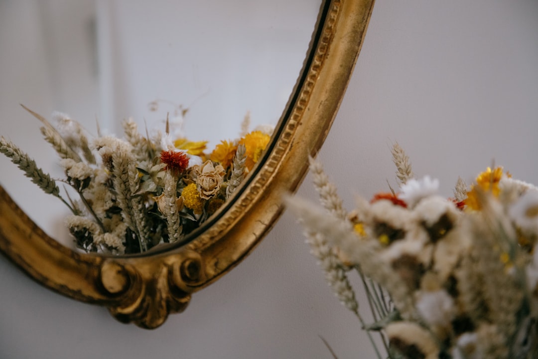 gold framed mirror with red and yellow flowers