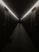 Minimalist neon-lit corridor with dark walls and glowing red lines leading into the distance.