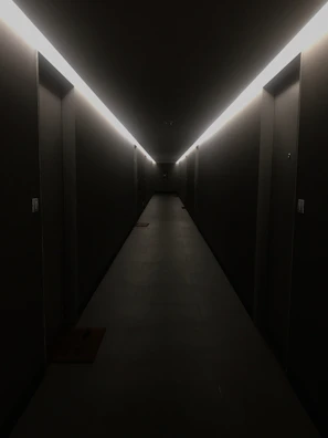 Minimalist neon-lit corridor with dark walls and glowing red lines leading into the distance.