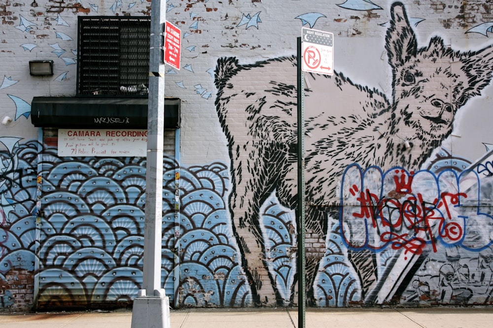 white metal pole near wall with graffiti